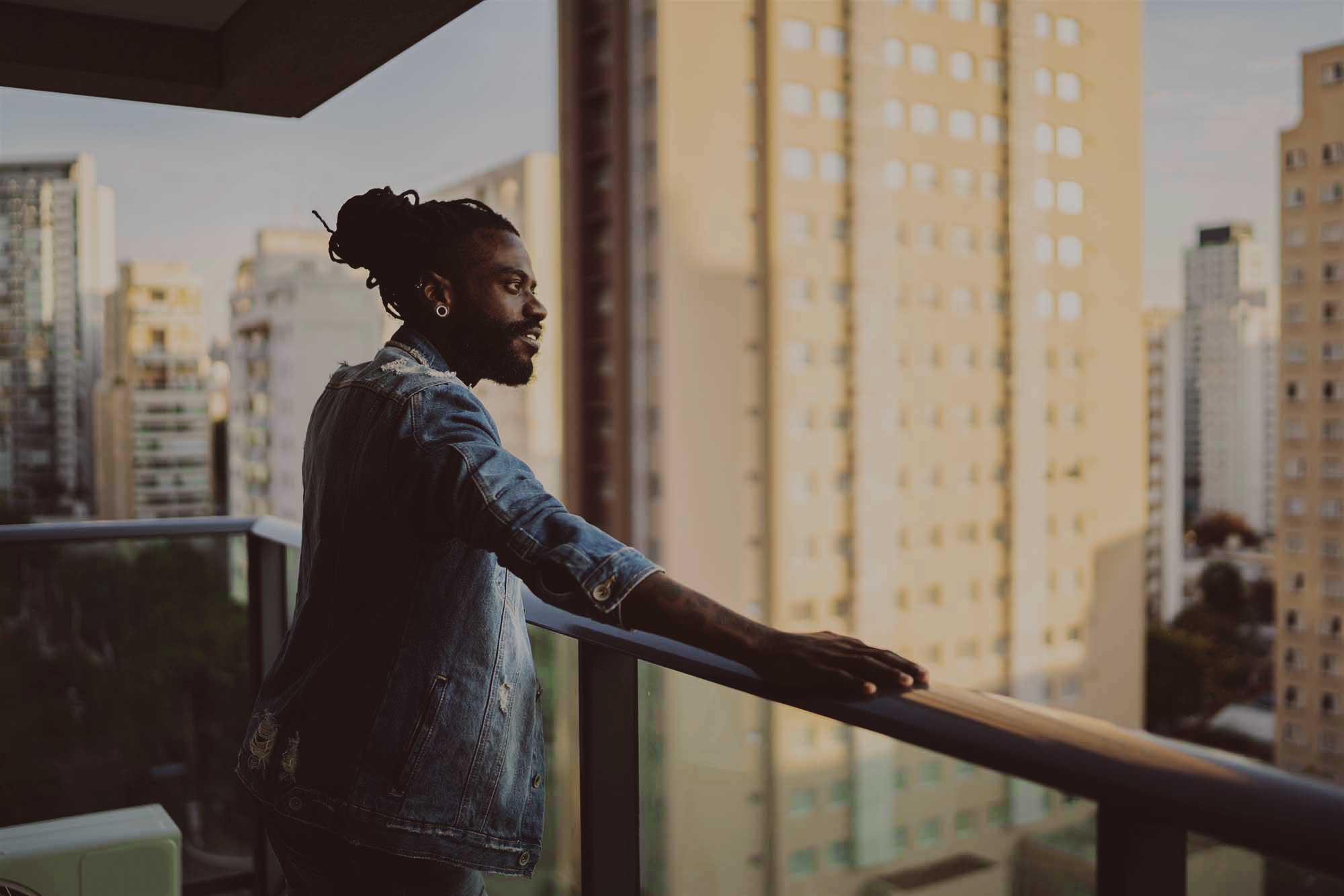 man standing on balcony looking over city